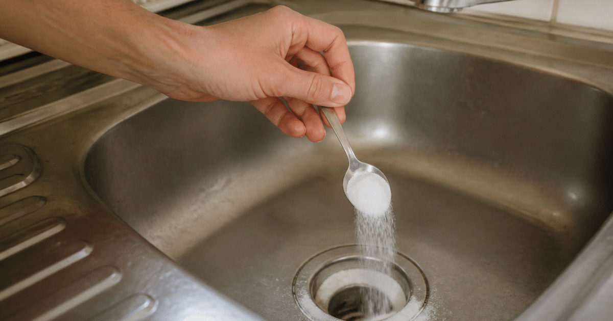 Main versant bicarbonate de soude dans evier bouche