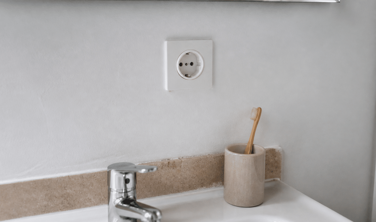Prise murale blanche installee au-dessus lavabo salle bain