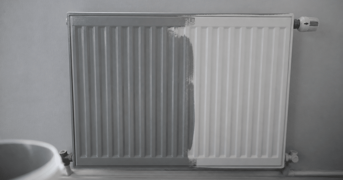 Radiateur blanc mural recouvert partiellement de peinture grise fraiche