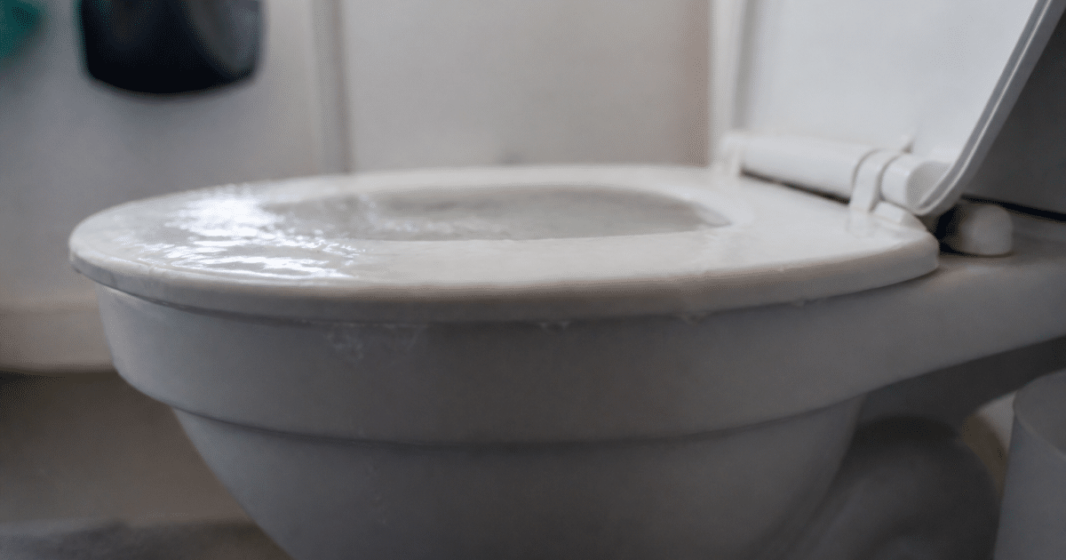 Cuvette toilettes remplie eau débordant au-dessus du rebord blanc