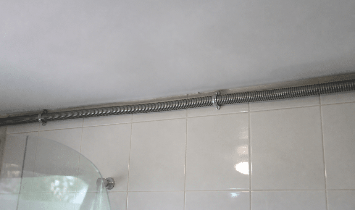 Gaine metallique fixee au plafond blanc salle bain