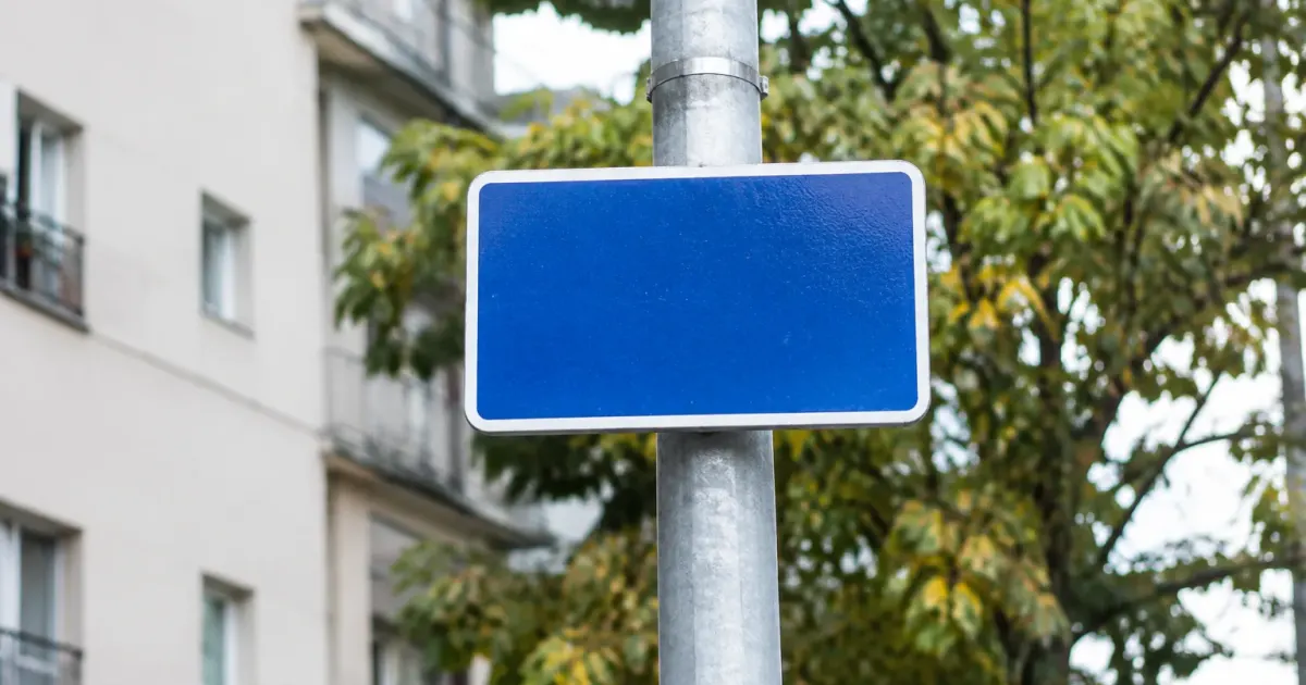 Panneau bleu de rue fixe sur un poteau gris