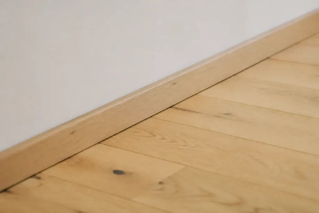 Parquet clair pose avec joint visible contre le mur