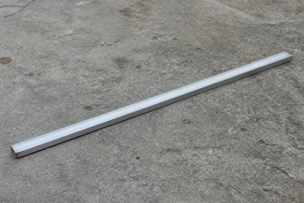 Regle aluminium posee sur sol beton gris