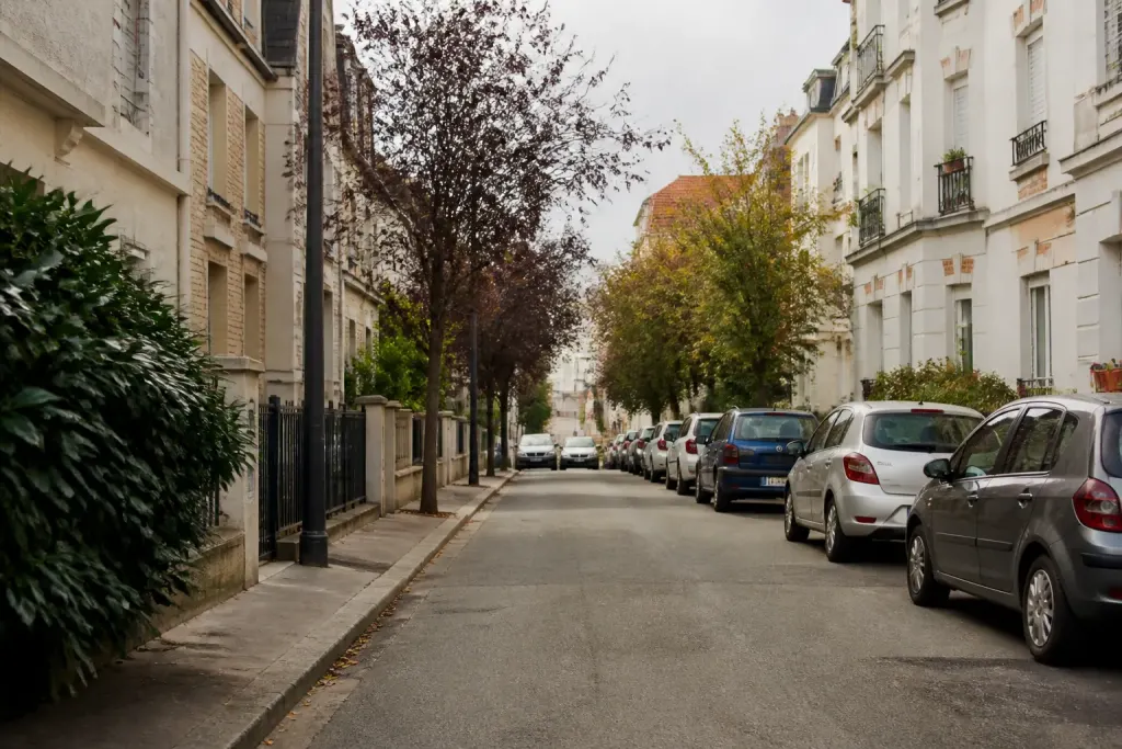Rue residentielle calme avec immeubles et voitures garees