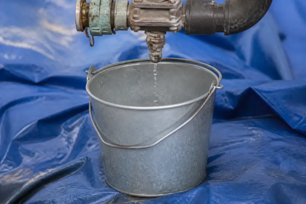 Seau metallique sous un raccord sur bache bleue